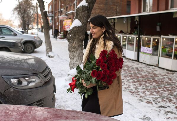 امرأة تحمل باقة من الورد فى مدينة أومسك الروسية - سبوتنيك عربي