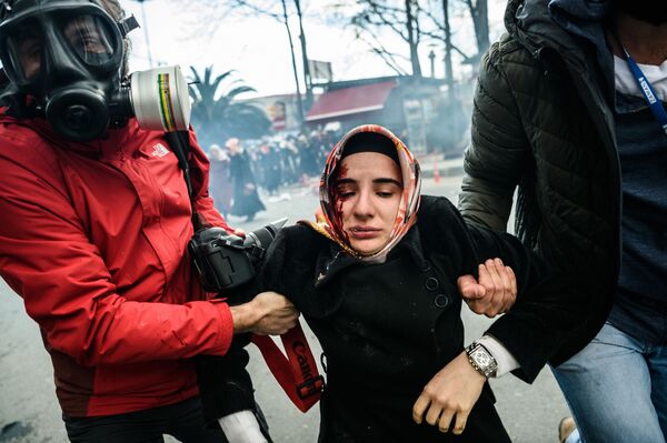 الصحفيون يحملون امرأة أصيبت بجروح جراء اصطدامات مع شرطة اسطنبول بالقرب من موقع جريدة زمتن التركية في اسطنبول، 5 مارس/ آذار 2016. - سبوتنيك عربي