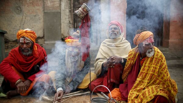 الهنديون المقدسون، أو رجال سادهو، يجلسون القرفصاء أمام النار في معبد باشوباتيني في كاذاماندو بنيبال، 6 مارس/ آذار 2016. - سبوتنيك عربي