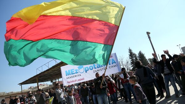 A Kurdish man waves a large flag of the Kurdish People's Protection Units (YPG) political wing, the Democratic Union Party (PYD), during a demonstration against the exclusion of Syrian-Kurds from the Geneva talks in the northeastern Syrian city of Qamishli on February 4, 2016 - سبوتنيك عربي