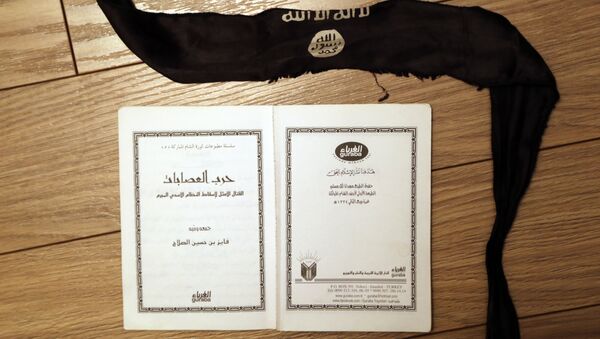 A suicide bomber's head-band and a manual, entitled “How to wage an ideal fight against the criminal Assad regime” found in an office of one of the Daesh jihadists in Shadadi. - سبوتنيك عربي