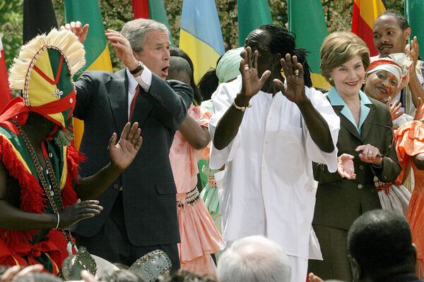 الرئيس الأمريكي جورج بوش (الابن) والسيدة الأولى لورا بوش يؤديان رقصة مع فريق موسيقي أفريقي بحديقة روز بالبيت الأبيض، واشنطن، 25 إبريل/ نيسان 2007. - سبوتنيك عربي
