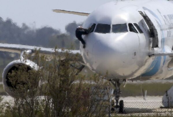 رجل يخرج من قمرة قيادة الطيار هارباً من الطائرة المخطوفة Egypt Air 181 بمطار لارنكا، القبرص 29 مارس/ آذار 2016. - سبوتنيك عربي