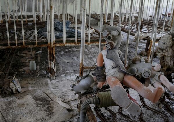دمية أطفال ترتدي قناعا ضد الغاز بين ركام منزل دُمر في مدينة بريبيات بالقرب من المحطة النووية تشيرنوبل، أوكرانيا 28 مارس/ آذار 2016. - سبوتنيك عربي