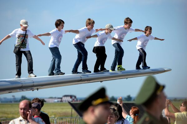أطفال يلتقطون صورة جماعية على جناح طائرة ياك-40 في مطار سوكول في البيرم، روسيا. - سبوتنيك عربي