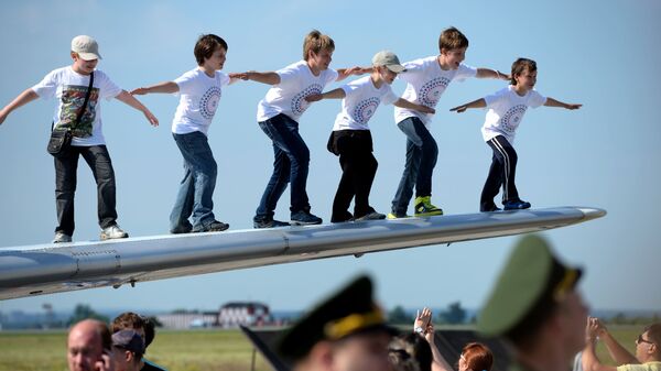 أطفال يلتقطون صورة جماعية على جناح طائرة ياك-40 في مطار سوكول في البيرم، روسيا. - سبوتنيك عربي
