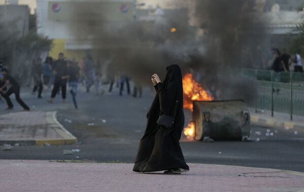 امرأة تلتقط صورة للاشتباكات والتصادمات بين الشرطة والمتظاهرين في البحرين، 5 أبريل/ نيسان 2016. - سبوتنيك عربي