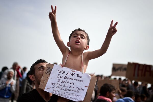 طفل لاجئ من سوريا، يحمل لافتة مكتوب عليها نطلب من حكومات الاتحاد الأوروبي مساعدتنا. وسوف نقتل أنفسنا لو قررت إعادتنا إلى تركيا. لا، لا، لا لتركيا!، مخيم خيوس للتسجيل باليونان، 3 أبريل/ نيسان 2016. - سبوتنيك عربي