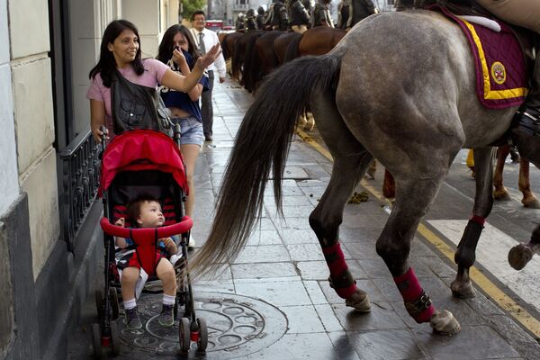 امرأة تدفع حصان الشرطي عن عربة طفلها، خلال الاحتجاجات التي أقيمت ضد المرشح للانتخابات الرئاسية كيكو فوجيموري في بيرو، 5 أبريل/ نيسان 2016. - سبوتنيك عربي