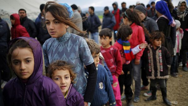 اللاجئون في مخيم إدوميني اليوناني يقفون في طابور للحصول على شاي، الحدود المقدونية-اليونانية، 11 أبريل/ نيسان 2016 - سبوتنيك عربي