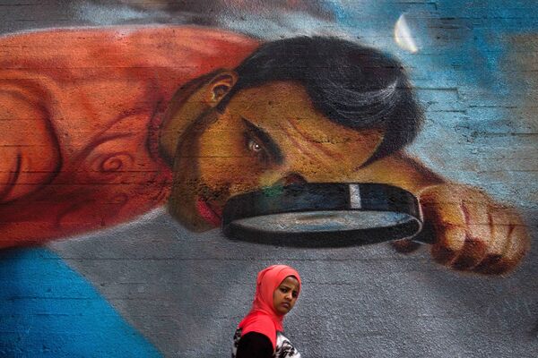 امرأة تمر بجوار جدارية كبيرة في إحدى شوارع بيروت، لبنان 4 مايو/ أيار 2016 - سبوتنيك عربي
