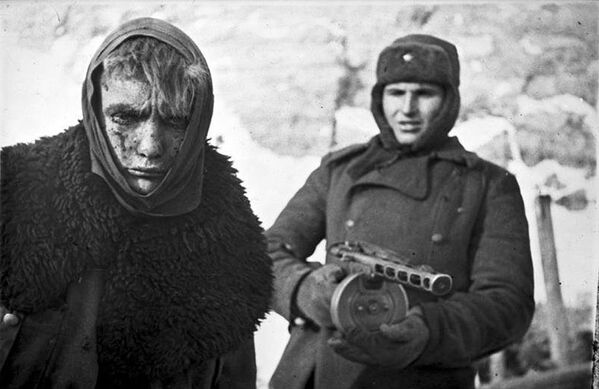 جندي سوفييتي يحمل بندقية ب.ب.ش-41 يرافق أسيرا ألمانيا نازياً - سبوتنيك عربي