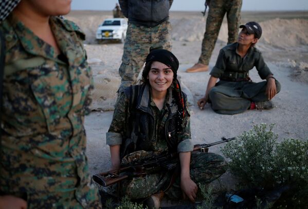 فتيات في قوات حزب العمال الكردي تبتسم للكاميرا وهي تحمل بندقية قنص، شمال العراق 29 أبريل/ نيسان 2016. - سبوتنيك عربي
