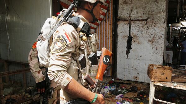 أحد أفراد الأمن العراقي أثناء تفقد انفجار بغداد - سبوتنيك عربي