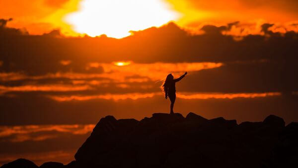 فتاة تلتقط صورة سيلفي لها على خلفية غروب الشمس في أدلير - سبوتنيك عربي