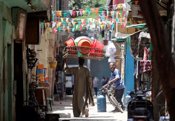 بائع صحون بلاستيكية على خلفية شارع مزيّن بمناسبة اقتراب شهر رمضان المبارك، القاهرة 1 يونيو/ حزيران 2016. - سبوتنيك عربي