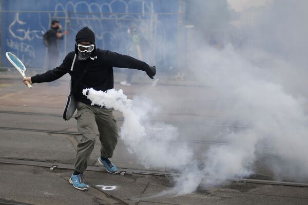 التنس - متظاهر يقوم بضربة تنس لقنبلة غازية مسيّلة للدموع في نانت، فرنسا 2 يونيو/ حزيران 2016. - سبوتنيك عربي