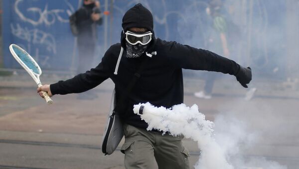 التنس - متظاهر يقوم بضربة تنس لقنبلة غازية مسيّلة للدموع في نانت، فرنسا 2 يونيو/ حزيران 2016. - سبوتنيك عربي