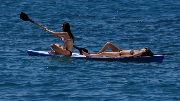 فتاتان على لوح في البحر قبال شواطئ أنفه بلبنان، 5 يونيو/ حزيران 2016. - سبوتنيك عربي