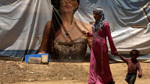 لاجئة سورية من حلب وطفلها على خلفية خيمة عليها رسم إعلاني، مخيم اللاجئين في لبنان 20 يونيو/ حزيران 2016 - سبوتنيك عربي