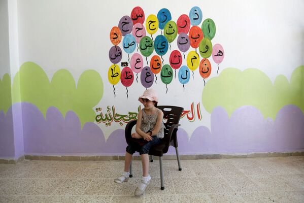 تلميذة سورية تجلس وخلفها الحروف الأبجدية - سبوتنيك عربي
