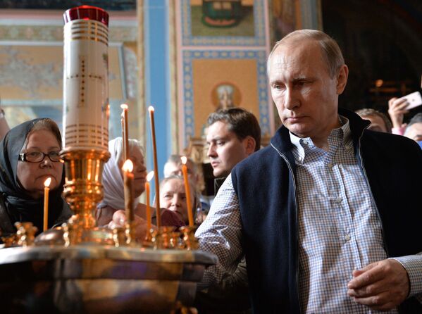 الرئيس فلاديمير بوتين يضع شمعة في كنيسة سباسو-بريوبراجينكس. - سبوتنيك عربي
