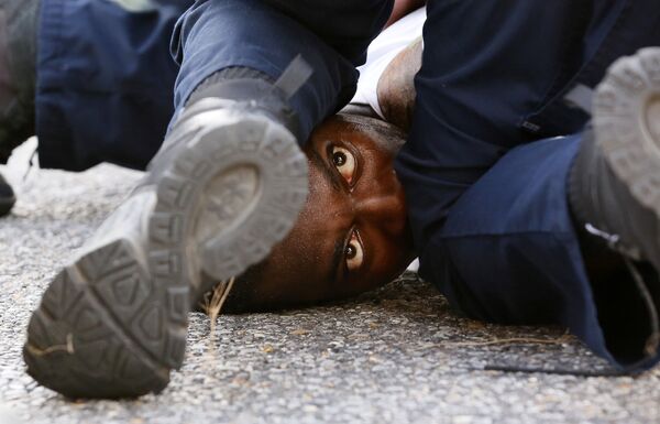 رجل يحتج ضد شرطي بعد مقتل المواطن الأمريكي (من أصول أفريقية) إلتون ستيرلينغ في لوزيانا، 9 يوليو/ تموز 2016. - سبوتنيك عربي