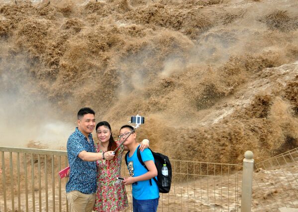 أشخاص يلتقطون صور سيلفي على خلفية شلال خوكاو، وهو أكبر شلال يطل على نهر خوانخي، الصين 10 يوليو/ تموز 2016 - سبوتنيك عربي