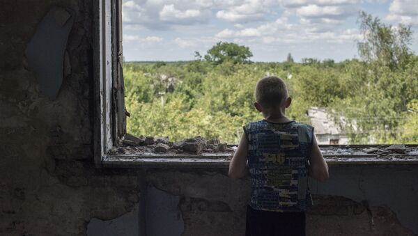 مراهق على شرفة مدرسة دمرت نتيجة قصف بقرية شاختي في جمهورية دونيتسك، أوكرانيا - سبوتنيك عربي