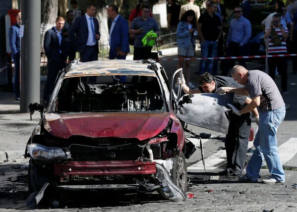 الشرطة في مكان انفجار السيارة التي كان يركبها الصحفي الروسي بافيل شيريميت في مدينة كييف، أوكرانيا 20 يوليو/ تموز 2016 - سبوتنيك عربي