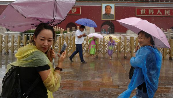 السياح تحت أمطار بكين الغزيرة، الصين 20 يوليو/ تموز 2016 - سبوتنيك عربي