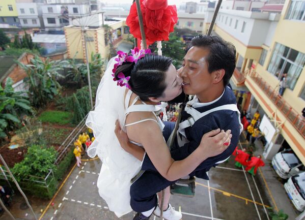 الاحتفال بالزواج (معلقين ما بين طوابق عمارة)على بعد عدة أمتار من سطح الأرض، الصين. - سبوتنيك عربي