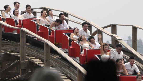 أزواج صينيون يحتفلون بزواجهم في مدينة الملاهي، الصين. - سبوتنيك عربي