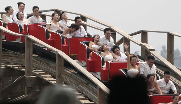أزواج صينيون يحتفلون بزواجهم في مدينة الملاهي، الصين. - سبوتنيك عربي