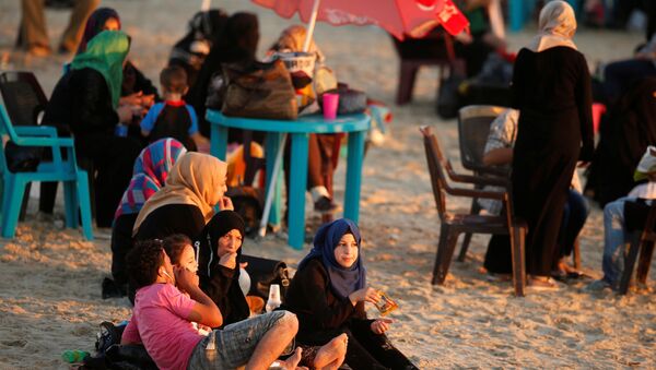 عائلة فلسطينية على شاطئ البحر في مدينة غزة، 19 يوليو/ تموز 2016 - سبوتنيك عربي