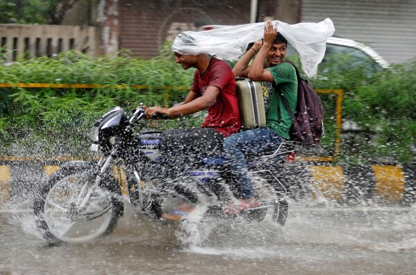 شابان تحت امطار غزيرة في الهند، 27 يوليو/ تموز 2016 - سبوتنيك عربي