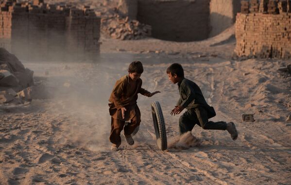 أطفال أفغانستانيون يلعبون بالعجل، 27 يوليو/ تموز 2016 - سبوتنيك عربي