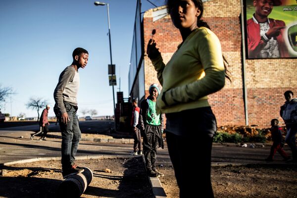 أطفال المنطقة السكنية سويتو بمدينة جوهانسبورغ جنوب أفريقيا، يغتنمون لحظة سلام ليلعبوا، 27 يوليو/ تموز 2016 - سبوتنيك عربي