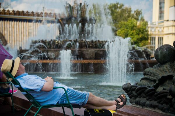 المواطنون الروس يجلسون بالقرب من نافورة المياه كايني تسفيتوك (الزهرة الحجر) في حديقة مركز معارض عموم روسيا في موسكو - سبوتنيك عربي