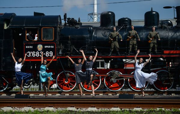 أعضاء حفل مسرحي على خلفية القاطرات البخارية على شرف عيد عمال السكك الحديدية في ضواحي موسكو. - سبوتنيك عربي
