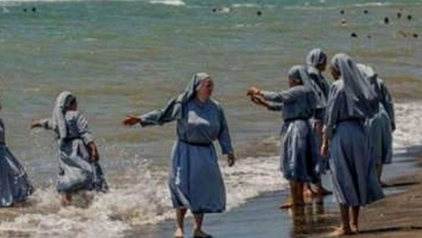 صورة لراهبات مسيحيات يلهون على شاطئ البحر بلباسهن الديني - سبوتنيك عربي