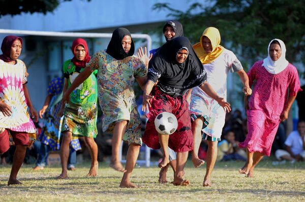 رجال اتشيه، يرتدون الملابس النسائية ويلعبون كرة القدم بمناسبة عيد الاستقلال الإندونيسي الـ 71 في باندا-أتشيه، إندونيسيا 20 أغسطس/ آب 2016 - سبوتنيك عربي