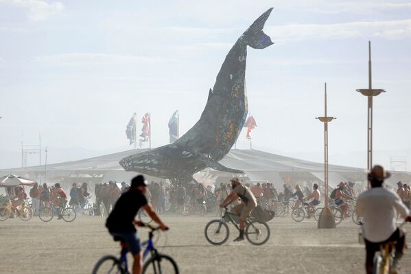 المشاركون (حوالي 70.000) من جميع أنحاء العالم  يتجمعون حول تمثال فني لحوت ضخم، وذلك خلال المهرجان الدولي للفنون في صحراء بلاك روك بنيفادا في الولايات المتحدة، 29 أغسطس/ آب 2016 - سبوتنيك عربي