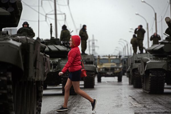 مرور إحدى الفتيات بجانب الدبابات الروسية - سبوتنيك عربي