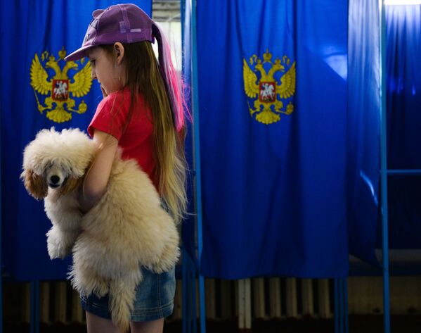 فتاة مع كلب خلال التصويت في الانتخابات البرلمانية الروسية فى مركز اقتراع في نوفوسيبيرسك - سبوتنيك عربي