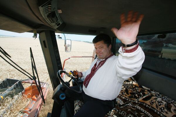 الرئيس الأوكراني بيوتر بوروشينكو وهو يقود مركبة الحصّادة. - سبوتنيك عربي