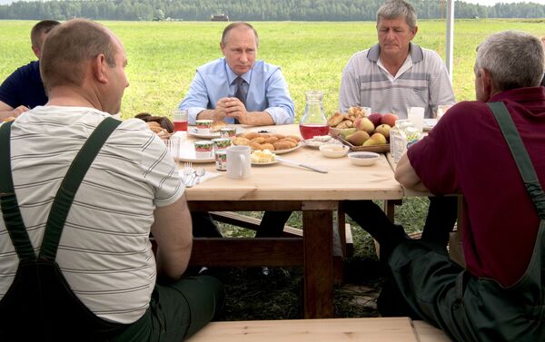 الرئيس الروسي فلاديمير بوتين يجلس مع المزارعين والفلاحين لدى زيارته لحقل دميتروفا غورا (جبل دميتروف) في إقليم تفيرسكايا. - سبوتنيك عربي