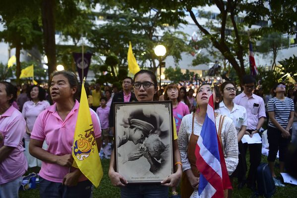 حشودات من الناس تخرج إلى الشوارع، حاملة صور ملك تايلاند بوميبول أدولياديج، أمام المستشفى الذي كان يتلقى العلاج فيه، بانكوك 13 أكتوبر/ تشرين الأول 2016 - سبوتنيك عربي