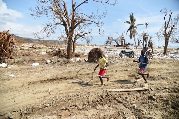 أطفال يلعبون بالعجل بعد انتهاء اعصار ماثيو في هاييتي، 10 أكتوبر/ تشرين الأول 2016 - سبوتنيك عربي