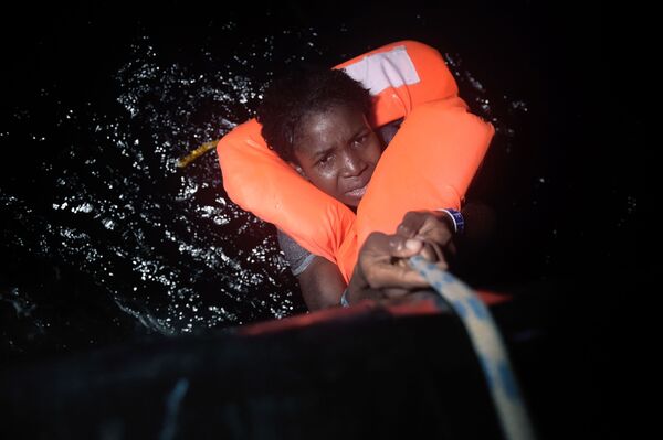 فتاة تمسك بالحبل خلال عملية إنقاذ المهاجرين قبالة السواحل الليبية، 12 أكتوبر/ تشرين الأول 2016 - سبوتنيك عربي